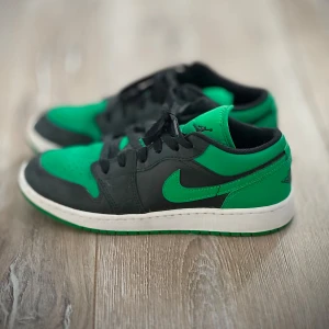 Gröna och svarta Air Jordan 1 low - Väldigt fint skick på skorna, inte mycket creasing alls. Använda fåtal gånger. 