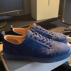 Mörkblå sneakers från Christian Louboutin - Säljer ett par snygga mörkblå sneakers från Christian Louboutin. Storlek 43 lite knappt använde, var ett få tal gånger.