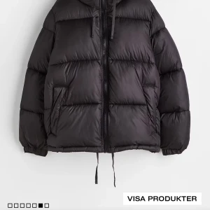 Svart pufferjacka - Säljer en svart pufferjacka som är perfekt för kalla dagar. Den har en dragkedja framtill och en mysig huva. Jackan är långärmad och har en loose passform, vilket gör den superbekväm. Perfekt för både höst och vinter!