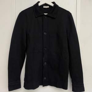 Säljer en stilren svart overshirt från Selected Homme i storlek M. Den har långa ärmar och knappar framtill. Perfekt för höst och vår, och funkar både till vardags och fest. Materialet känns mjukt och bekvämt. Passar dig som gillar en klassisk och tidlös stil. Skick: Bra - Artnr: D069