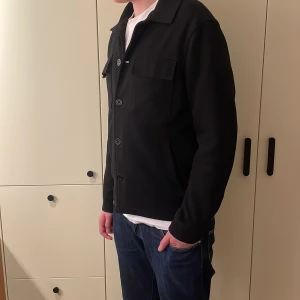 Svart Zara overshirt - Fet Zara overshirt som säljs pga att den inte kommer till användning. Den är använd ett fåtal gånger och har inga stora tecken på användning, och är därför i 9/10 skick!. Modellen är cirka 180 och om du har flera frågor kom dm:)!