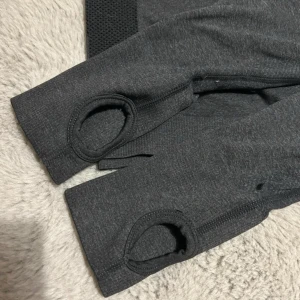 Grå träningsshorts med dragkedja - Snygga grå tränings topp. Perfekta för intensiva träningspass eller en avslappnad dag.