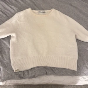 Vit tröja från Zara - Säljer en mysig vit tröja från Zara. Tröjan har en enkel design med rund hals med tre kvarts armar 