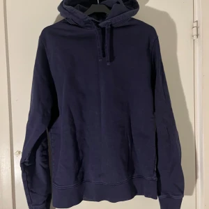 Mörkblå hoodie från These Glory Days - Säljer en stilren mörkblå hoodie från These Glory Days. Den har en klassisk design med huva och dragsko, samt långa ärmar. Perfekt för en avslappnad look.