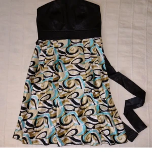 Kort y2k klänning i siden/satin  - Kort klänning i sidenliknande tyg. Med knytband och resår i ryggen. Sparsamt använd men det finns en del dragna trådar i tyget. Klänningen är tyvärr ostruken på bilderna. Vet inte säkert vad det för storlek men skulle säga XS/S (kanske även funkar till M)