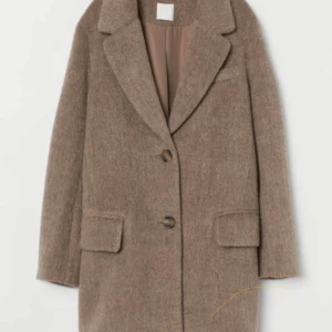 Beige kappa med knappar - Snygg beige kappa med klassisk design och knappar framtill. Den har långa ärmar och två fickor. Perfekt för kyligare dagar.