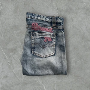 Grå jeans från Replay - Snygga grå jeans från Replay med broderad logga på bakfickan. De har en klassisk femficksdesign och en bekväm passform. Perfekta för en avslappnad stil. Vintage jeans.                                                                                             Gylfknapp saknas
