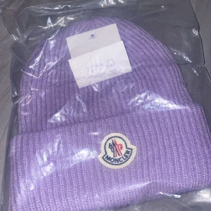 Lila moncler mössa - Snygg lila moncler mössa som är perfekt för vintern säljs för 300kr kom privat för mer information.