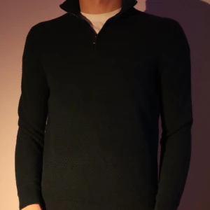 Mörkgrön tröja med dragkedja i kashmirblend från Massimo Dutti - Snygg mörkgrön tröja från Massimo Dutti med dragkedja i kashmir och texturerat mönster. Perfekt för kyligare dagar med sin stilrena design och bekväma passform.