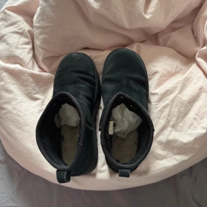 Svarta UGG - Säljer ett par svarta boots från UGG med mjukt foder och robust sula. Perfekta för kyliga dagar.