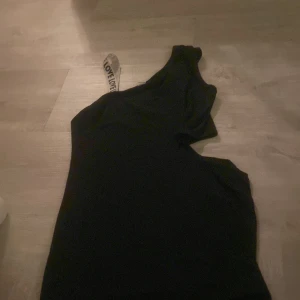 Svart oneshoulder klänning från Shein - Snygg svart oneshoulder klänning från Shein. Perfekt för en stilren look med en unik axelbandslös design. Passar utmärkt för olika tillfällen.