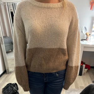 Beige och brun stickad tröja - Mysig stickad tröja i beige och brun med rund hals och långa ärmar. Perfekt för kyliga dagar och ger en avslappnad look. Passar bra till jeans eller leggings🤍