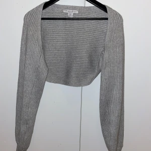 Grå ribbad bolerotopp från Amisu - Snygg grå ribbad bolerotopp från Amisu/NewYorker. Perfekt att ha över ett linne nu i höst!! 🍂Passar både till vardags och fest! 💫 Aldrig använd då jag ville ha den lite oversized så tyckte denna blev för liten tyvärr! 