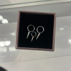 Peak Hoops Mini Steel - Jag säljer ett par silvriga och trendiga örhängen från Edblad med nitar. Jag säljer även ett örhänge i mini med nit från Edblad (råkat tappa bort det ena tyvärr). Alla örhängen är knappt använda eftersom att jag bara använder guld smycken❤️