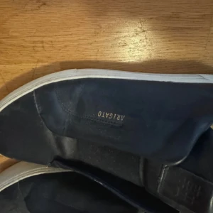 Axel Arigato Skor - Mörkblå Arigato 90s i läder, storlek 42 men passar 43, köptes för ett år sedan därav priset men kan byta.