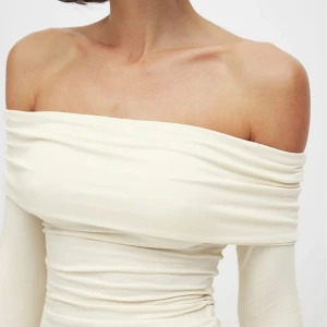 Krämfärgad offshoulder topp - Säljer en superfin krämfärgad offshoulder topp. Den är tight och har långa ärmar, perfekt för en stilren look. Toppen är i ett mjukt och stretchigt material som sitter bekvämt på kroppen. Endast testad med pris lappen kvar. Säljer för 200kr + frakt  