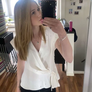 Vit omlottopp - Säljer denna superfina och populära vita blusen med knytning i sidan. Perfekt till festliga tillfällen eller bara att ha allmänt som jag. Kan sänka priset vid snabb affär