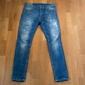 Dondup jeans - Riktigt goa ljusblåa dondup jeans i storlek 34 med riktigt schyssta slitningar och unikt rött dondup märke på vänstra låret. Skick 9/10 då de använts men inte har några riktiga skador. Passform - Slim Inga byten