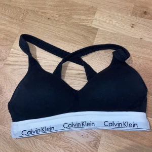 Svart sport-bh från Calvin Klein - Säljer en svart sport-bh från Calvin Klein i storlek S. Den har korsade axelband och en elastisk kant med Calvin Klein-loggan i vitt. Inga defekter! 