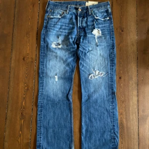 Vintage Jeans - Jeans från Hollister med många slitningar på framsidan. Riktigt najs passform, baggy/vida.