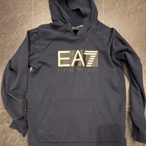 EA7 hoodie - Fin blå EA7 tunnare hoodie i storlek 150 / 12 år i användt men i gott skick 