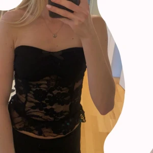 Topp - Spetstopp i storlek XS. Svart tyg vid bysten så den är inte genomskinlig där. Liten rosett längst upp och en volang längst ner. Aldrig använd. Vid fler bilder/frågor skriv! Prisförslag tas emot❤️