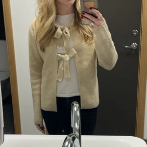 Kofta med rosetter - Säljer en söt beige ribbad kofta med rosetter fram🥰 säljer då den tyvärr inte kommer till användning! Xxs men sitter som xs/s❤️