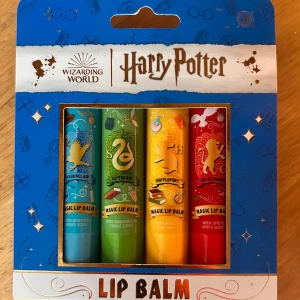 Lipbalmset med Harry Potter-motiv! - Fint set med 4 olika lipbalms med Harry Potter-motiv. Ravenclaw "Mystical berry scent", Slytherin "Gingerbread cookie scent", Hufflepuff "Vanilla bean scent" & Gryffindor "Spiced apple scent". 4 x 3,5 g. Ny och oöppnad. 