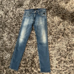 Replay  Abbass - Snygga blå jeansbyxor med en klassisk femficksdesign och lätt slitna detaljer. De har en knappgylf och är i en straight passform. Perfekta för en avslappnad stil.