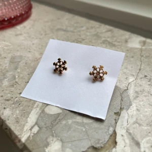Guldörhängen med snöflingedesign - Snygga små guldörhängen formade som snöflingor. Perfekta för att ge en subtil men elegant touch till din outfit. De har en fin detaljrikedom och är lätta att bära.