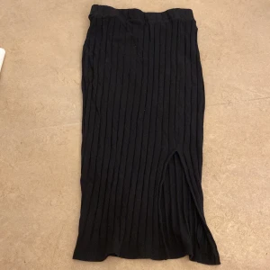 Svart ribbad kjol - Snygg svart ribbad kjol med slits. Perfekt för en stilren look. Kjolen har en elastisk midja för bekväm passform. Skrivvv❤️❤️🫶🏼