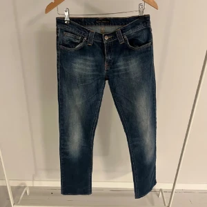 Blå jeans från Nudie Jeans - Säljer ett par klassiska blå jeans från Nudie Jeans. De har en snygg liten slitning på knäet, riktigt fet tvätt, STEAL! Model: lean dean som är bland de mest eftertraktade!