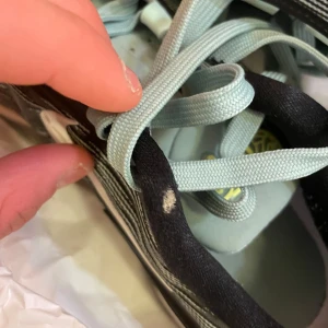 Nike basketskor med svart vit och grönt design - Snygga Nike basketskor med en stilren svart vit och grön design. Skorna har snörning och en bekväm passform, perfekta för basket och träning. De har en slitstark sula och en modern look.