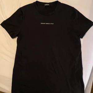 Svart t-shirt från Dondup - Snygg svart t-shirt från Dondup med texten 'MADE IN ITALY' tryckt på bröstet. Perfekt för en stilren och enkel look.