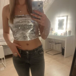Nyårstopp - Snygg och glittrig silverfärgad tubtopp täckt med paljetter. Perfekt för en festlig kväll eller nyår. Säljer då jag tycker den är lite för stor på mig :)