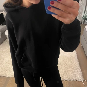 Svart hoodie  - Säljer den mysigaste svarta hoodien från ginatricot då den inte kommer till användning eftersom jag har flera likadana. Den är endast använd ett fåtal gångeroch därför i superbra skick. Storlek XXS men passar även fler storlekar beroende på hur man vill att den ska sitta. Tveka inte att höra av er med frågor eller lägga prisförslag!