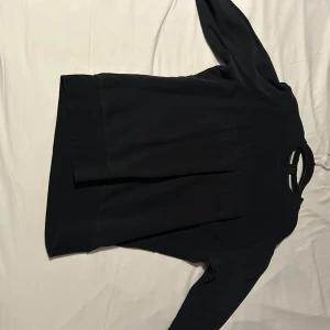 Svart långärmad Hugo boss tröja - Säljer en stilren svart långärmad Hugo boss tröja. Perfekt för en minimalistisk look och passar till många olika outfits. Tröjan har en enkel design utan mönster eller detaljer.