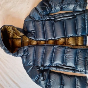 zara pufferjacka - Säljer en snygg blå pufferjacka från Zara Man. Jackan har en glansig yta och är perfekt för kyliga dagar. Den är långärmad och har en praktisk dragkedja framtill. Insidan är fodrad i en kontrasterande brun färg. pris kan såklart diskuteras!!!