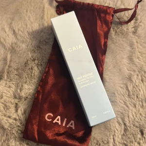 CAIA SOS Rescue Glowing Oil Mist - Säljer en CAIA SOS Rescue Glowing Oil Mist som ger huden en strålande lyster. Innehåller niacinamide och blue tansy oil, passar alla hudtyper. Perfekt för att fräscha upp huden när som helst.