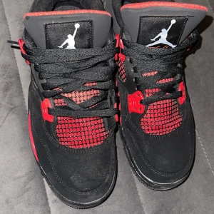 Svarta och röda Nike Air Jordans - Snygga Nike Air Jordans i svart och rött med klassisk Jumpman-logga. Skorna har snörning och en iögonfallande design med röda detaljer på sidorna och tungan.