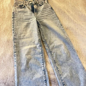 Jeans från Gina Tricot  - Säljer ett par blå jeans från Gina Tricot. De har en hög midja och mer av en straight fit. Storlek: 34 
