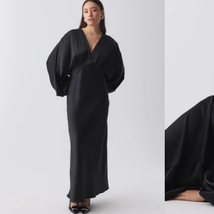 Svart satinlångklänning - Elegant svart långklänning i satin med v-ringning och långa ärmar. Endast använd en gång, så fin!!!