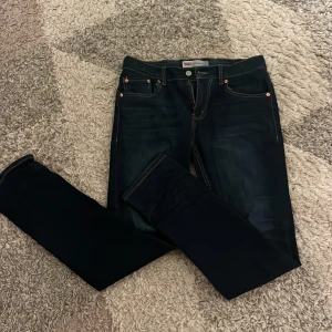 Levi's 512 Slim Taper Jeans - Snygga Levi's 512 Slim Taper jeans i mörkblå denim. De har en slim passform med avsmalnande ben och klassiska fem fickor. Perfekta för en stilren look.