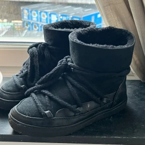Inuikii skor svarta  - Snygga svarta boots med tjock snörning och vadderad insida från märket Inuikii. Storlek 36,5 (fungerar även för 37). Köpta den här säsongen. Perfekta för kyligare dagar med sin robusta design och bekväma passform. Nypris ca 3000 säljes för 1800. 