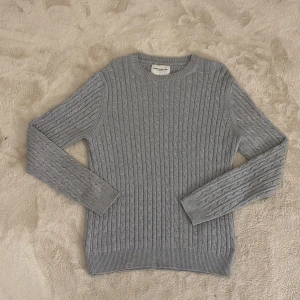 Grå stickad tröja från These Glory Days - Säljer en stilren grå stickad tröja från These Glory Days. Passar både män och kvinnor alltså unisex. Tröjan har ett klassiskt kabelstickat mönster och långa ärmar. Perfekt för kyligare dagar. Hör av dig vid funderingar och pris kan diskuteras vid snabb affär mvh Malte 