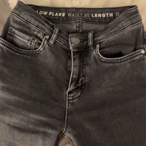 Grå low flare jeans - Snygga grå low flare jeans med fransiga benslut. De har en låg midja och klassisk femficksdesign. Perfekta för en avslappnad stil med en modern twist. Har sprättat upp de då de va lite korta💗