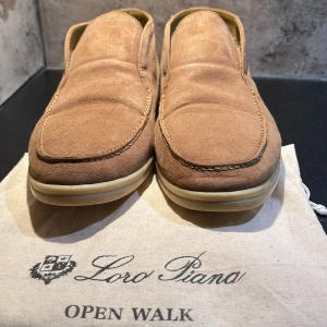 Loro piana open walk loafers - Säljer ett par eleganta bruna loafers från Loro Piana i modellen Open Walk. Skorna är tillverkade i mjuk mocka och har en bekväm innersula. Perfekta för en stilren look. Använda en del men fortfarande riktigt bra skick förutom lite crease! Skriv vid funderingar 😁 dustbag ingår🌟🤝