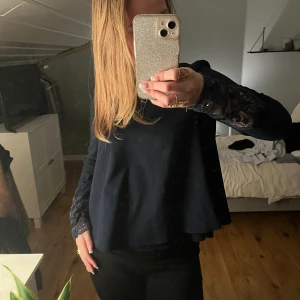 Marin blå blus med spetsdetaljer - Elegant marinblå blus med långa ärmar och vackra spetsdetaljer vid ärmsluten. 🥰