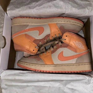 Air Jordan 1 Mid Apricot Orange - Otroligt snygga skor!! Använda kanske 2-3 gånger. Fint skick men ytterst lite smuts. Priset går alltid att diskutera och vid frågor så är det bara att höra av sig☺️