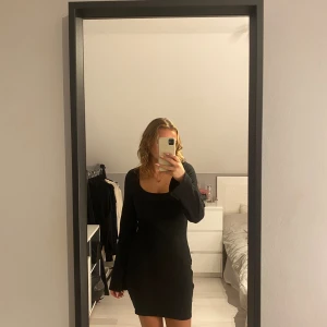 Svart ribbad klänning från H&M - Säljer en snygg svart ribbad klänning från H&M. Den har en tight passform och långa ärmar, perfekt för både vardag och fest. Klänningen är i storlek M och är superbekväm att ha på sig. Passar perfekt till höst och vinter!